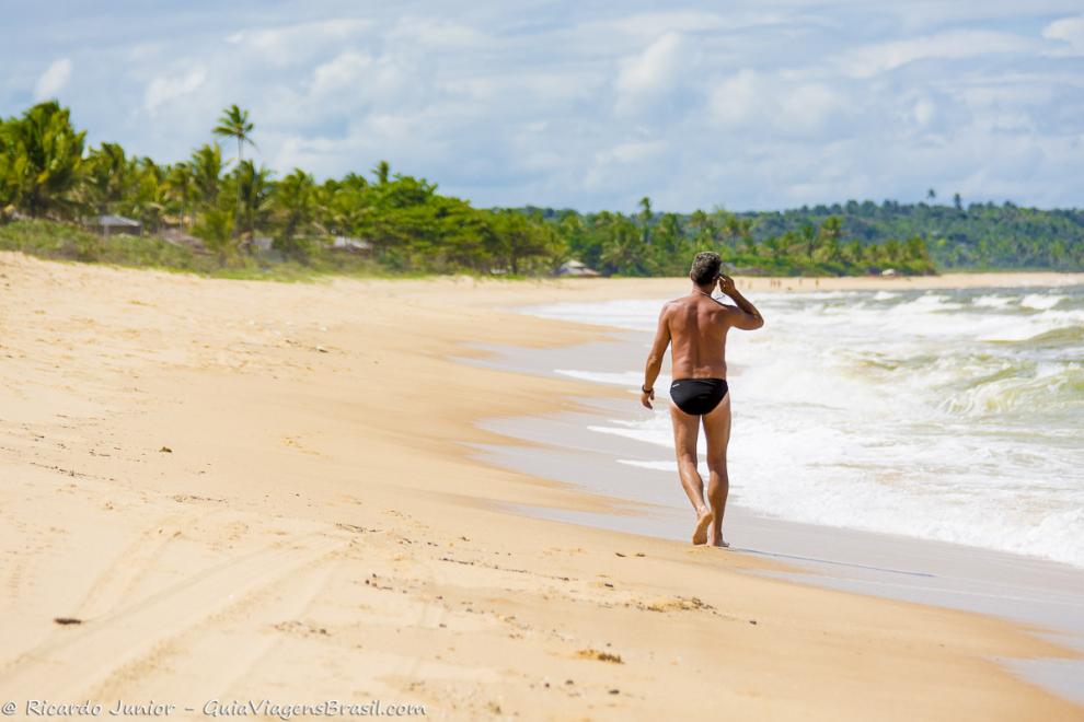 Imagem de um homem passeando pelas areias da Praia de Caraiva.